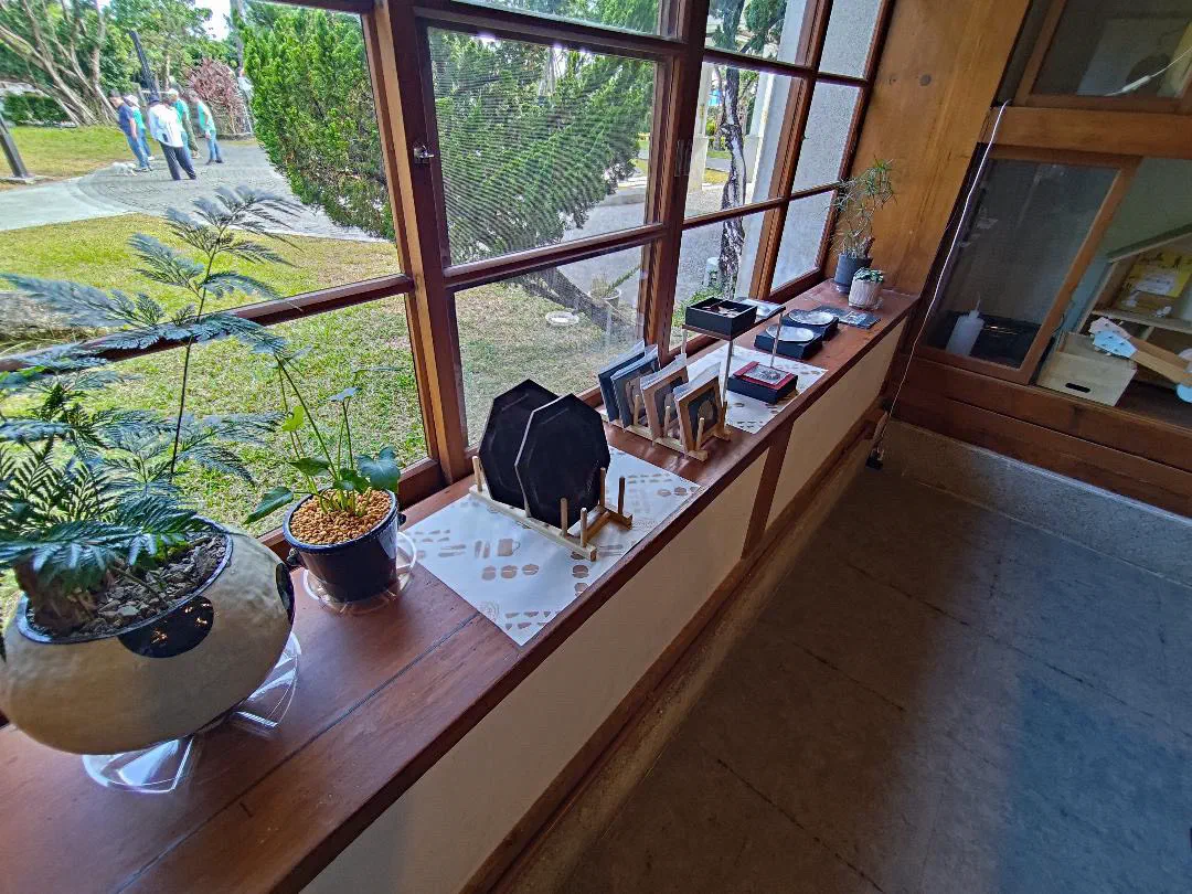 放送局窗台上的八角陶餐盤、錫器與窗外庭園